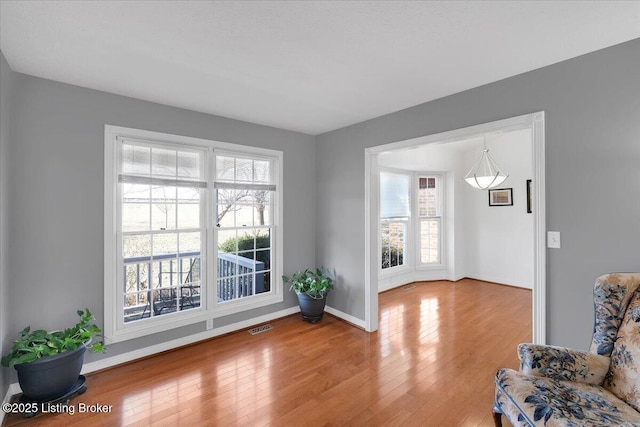 interior space with wood-type flooring, visible vents, and baseboards