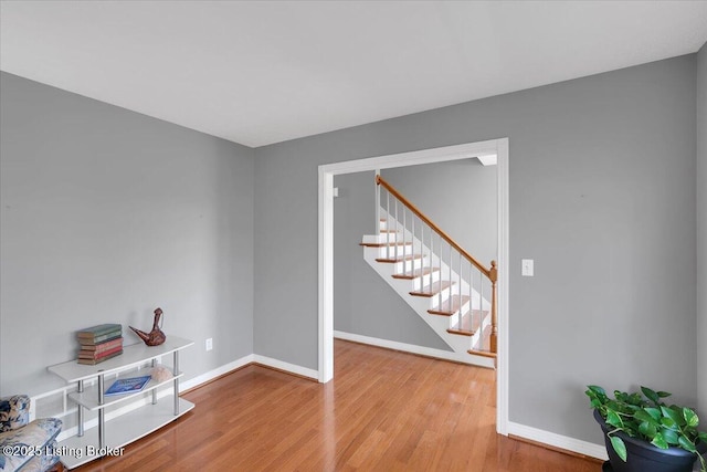 interior space with stairs, baseboards, and wood finished floors