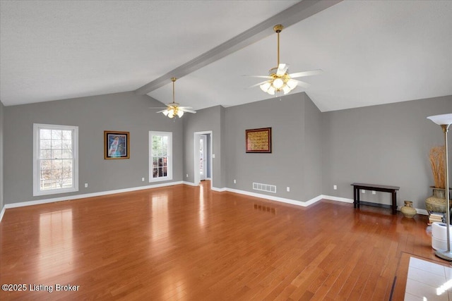 unfurnished living room featuring baseboards, visible vents, ceiling fan, wood finished floors, and vaulted ceiling with beams