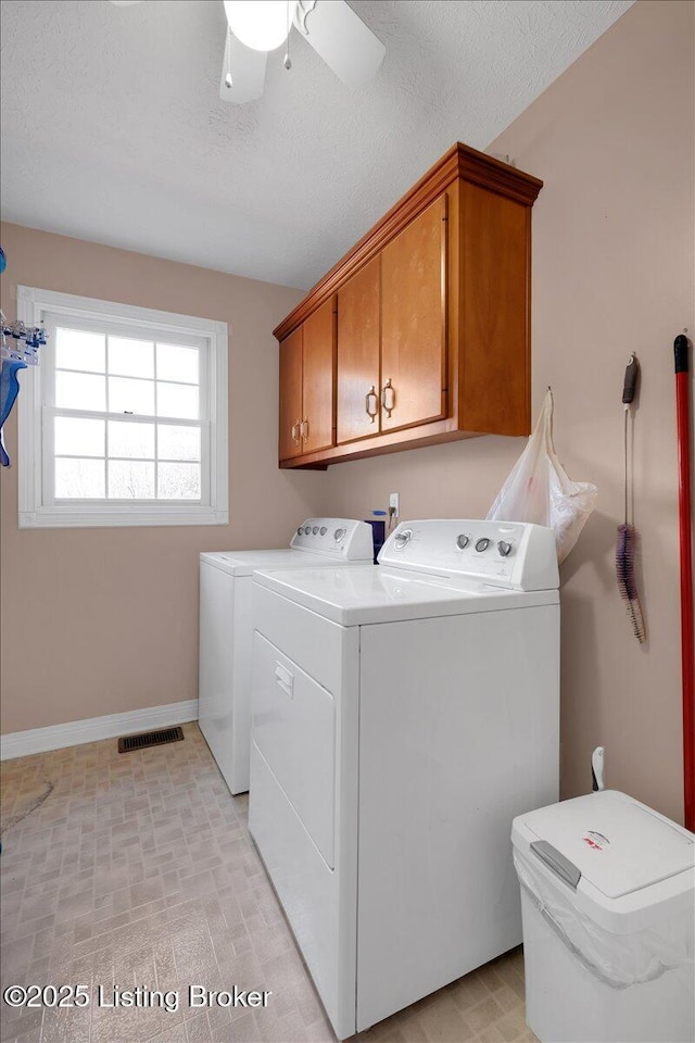 clothes washing area featuring cabinet space, visible vents, a textured ceiling, separate washer and dryer, and baseboards