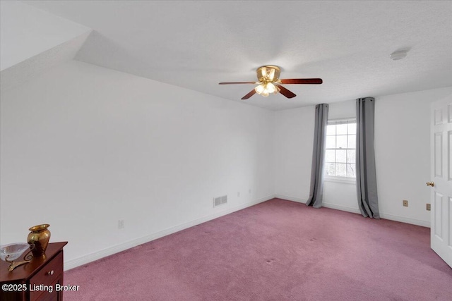 empty room featuring light colored carpet, visible vents, ceiling fan, and baseboards