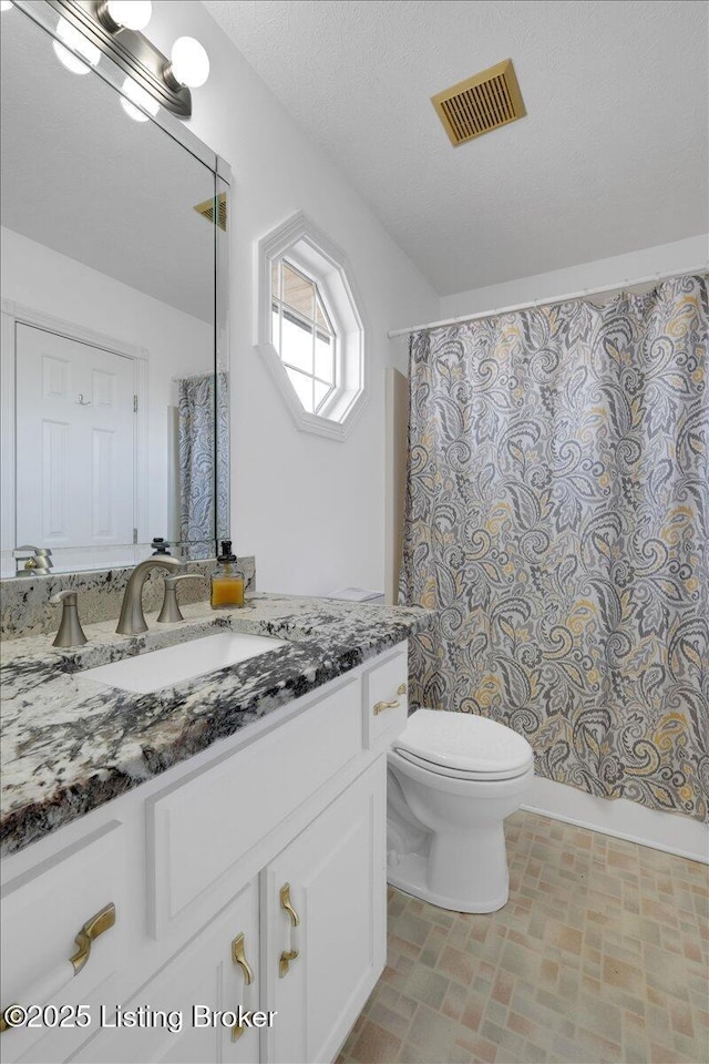 full bath featuring a textured ceiling, curtained shower, toilet, vanity, and visible vents