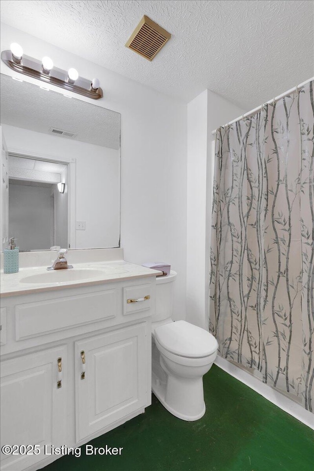 full bathroom featuring toilet, visible vents, a textured ceiling, and vanity