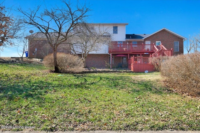 back of house with brick siding, a yard, and a deck