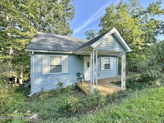 bungalow featuring roof with shingles