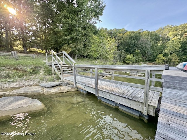 dock area featuring a water view and a wooded view