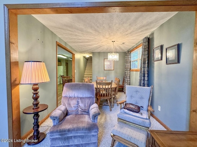 sitting room with baseboards, stairway, carpet, a textured ceiling, and a notable chandelier