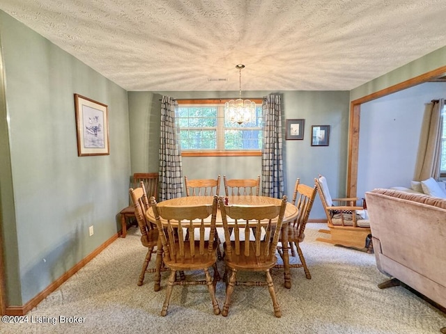 dining room with light carpet, baseboards, a chandelier, and a textured ceiling