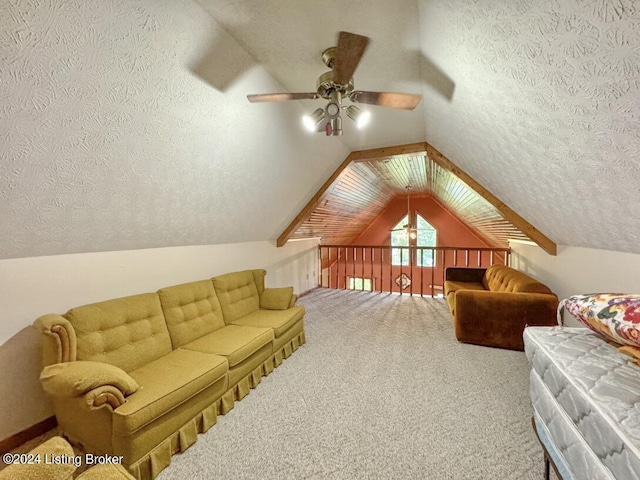 interior space with a ceiling fan, carpet flooring, vaulted ceiling, and a textured ceiling