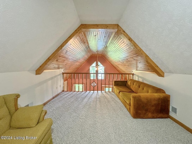 additional living space with baseboards, visible vents, lofted ceiling with beams, carpet, and a textured ceiling