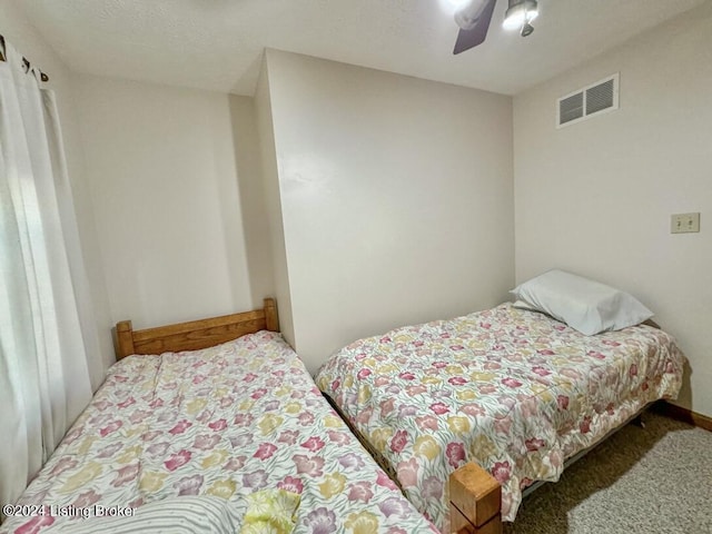 carpeted bedroom with ceiling fan and visible vents