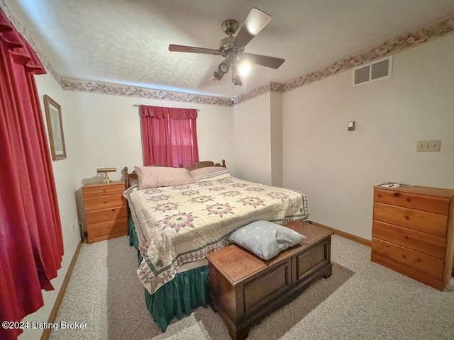 bedroom with baseboards, visible vents, ceiling fan, a textured ceiling, and carpet floors