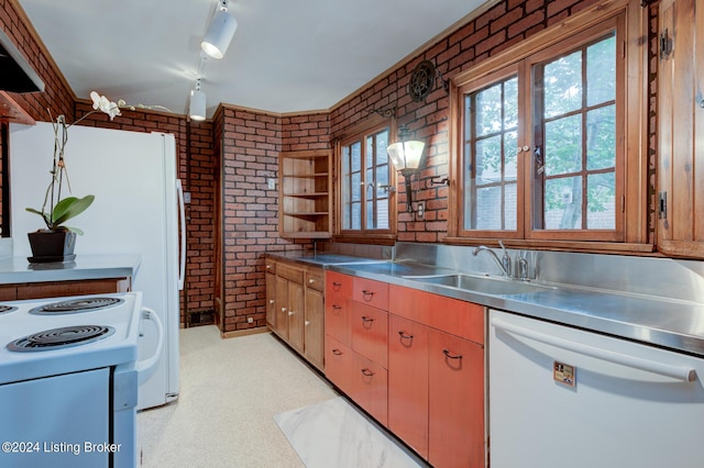 kitchen with white appliances, brick wall, stainless steel countertops, and a sink