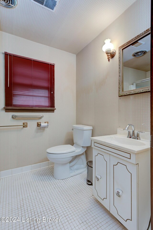 bathroom featuring tile patterned flooring, toilet, vanity, and wallpapered walls