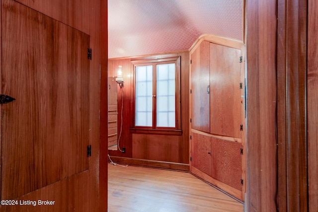 interior space with wooden walls and light wood finished floors