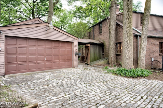 view of front facade featuring a detached garage, brick siding, and an outdoor structure