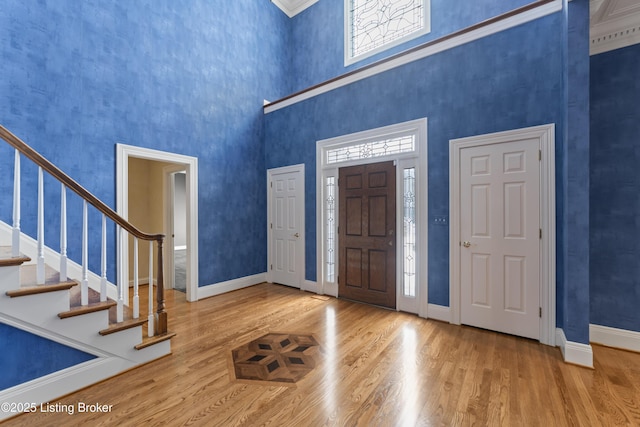 foyer with stairway, wood finished floors, and baseboards