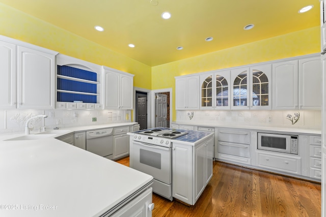 kitchen featuring glass insert cabinets, white appliances, tasteful backsplash, and white cabinetry