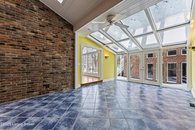 unfurnished sunroom featuring lofted ceiling with skylight and ceiling fan