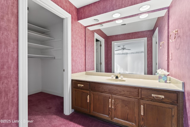 bathroom featuring vanity, ceiling fan, baseboards, and wallpapered walls