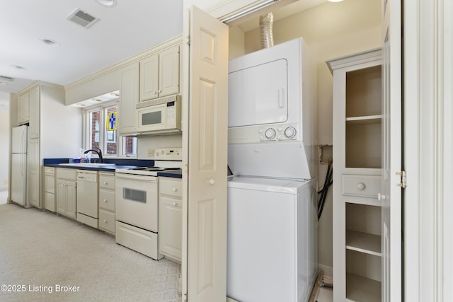 laundry room with visible vents, a sink, recessed lighting, stacked washer / dryer, and laundry area