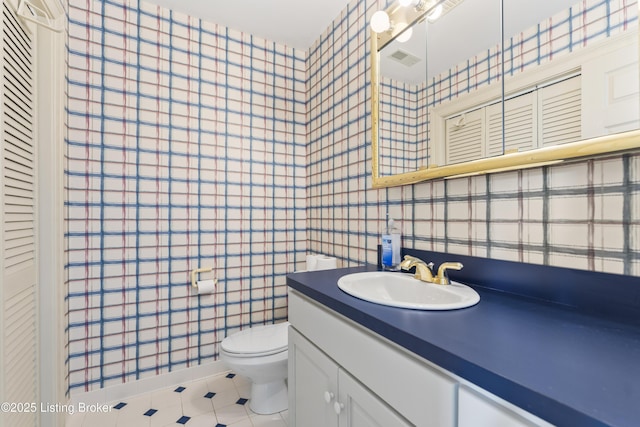 bathroom featuring tile patterned flooring, toilet, vanity, and visible vents