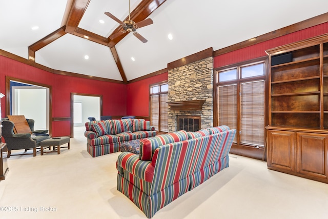 living room with beamed ceiling, high vaulted ceiling, a stone fireplace, light colored carpet, and ceiling fan