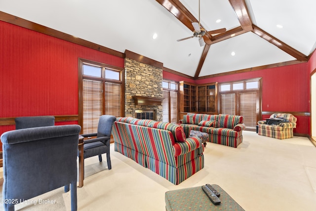 living room featuring plenty of natural light, carpet, a stone fireplace, and a ceiling fan