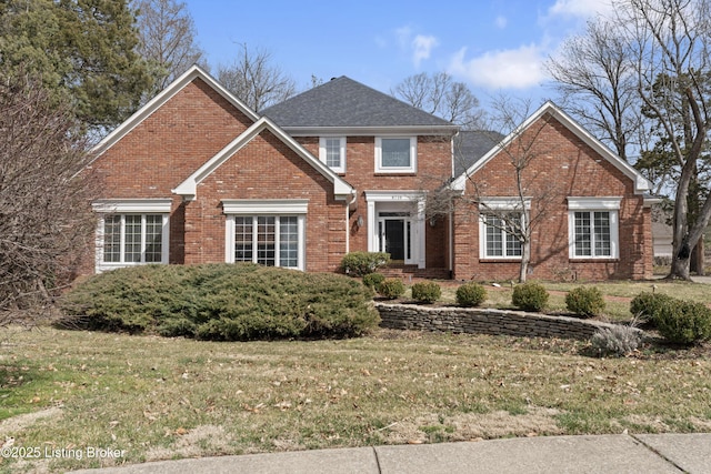 traditional-style home featuring a front lawn and brick siding