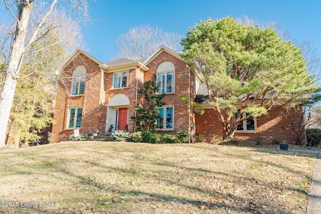 view of front facade with a front lawn and brick siding