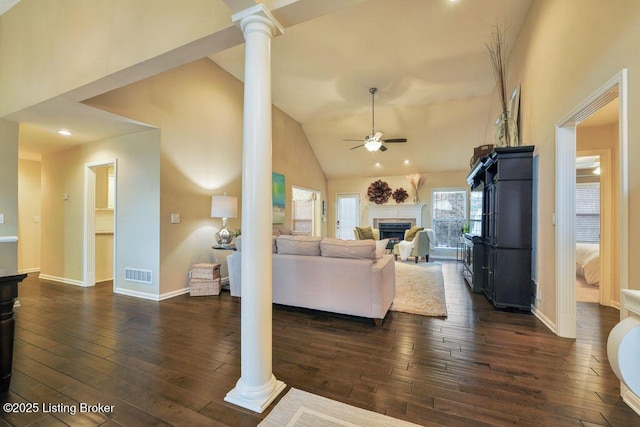 living area featuring visible vents, ceiling fan, ornate columns, and dark wood-style flooring