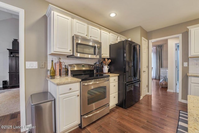 kitchen featuring backsplash, white cabinets, stainless steel appliances, and dark wood-style flooring