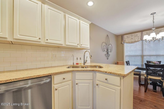 kitchen with dark wood finished floors, a sink, dishwasher, tasteful backsplash, and a chandelier