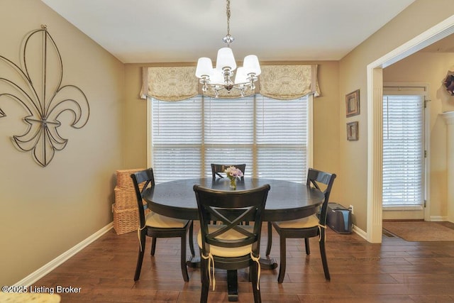 dining area featuring wood finished floors, baseboards, and a chandelier