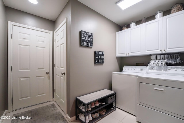 laundry area with light tile patterned floors, cabinet space, and separate washer and dryer