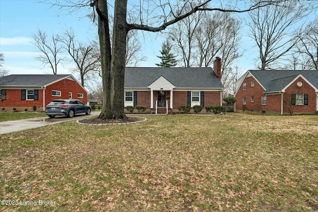 view of front of house with brick siding, a chimney, and a front lawn