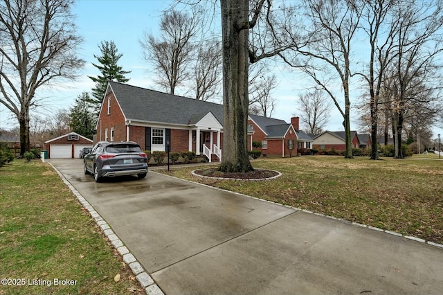 view of front of home with a garage, an outbuilding, brick siding, and a front lawn