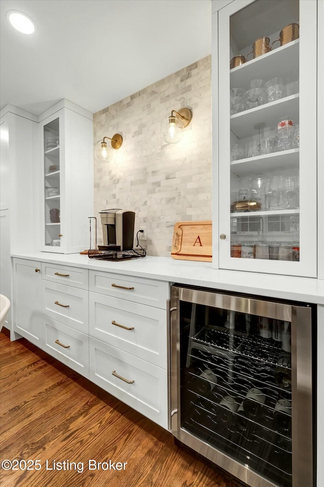 bar featuring a bar, wine cooler, and dark wood-style flooring