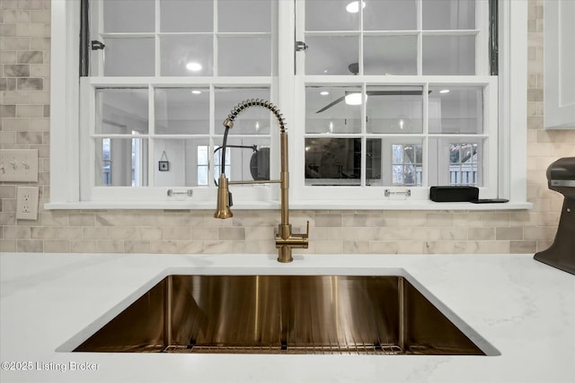 interior details featuring light countertops, a sink, and backsplash