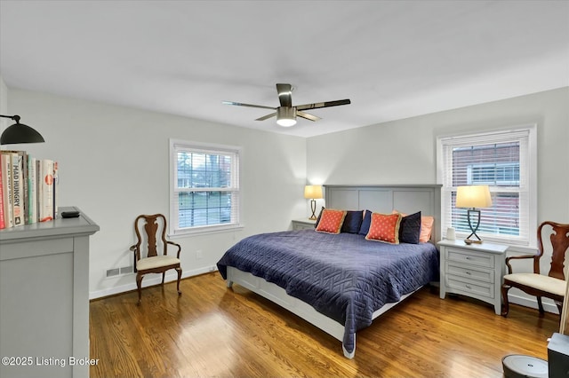 bedroom with ceiling fan, baseboards, and wood finished floors