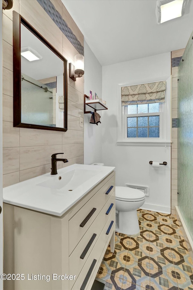 bathroom featuring a shower, vanity, and toilet