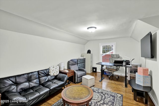 living room featuring lofted ceiling, wood finished floors, and baseboards