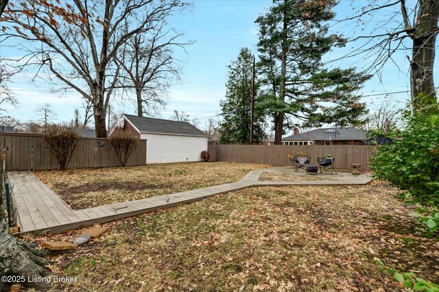 view of yard with an outbuilding, a patio, and a fenced backyard