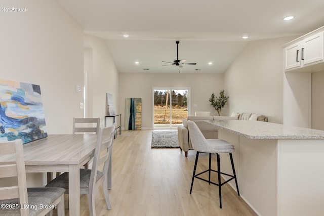 dining space with a ceiling fan, recessed lighting, lofted ceiling, and light wood-style flooring