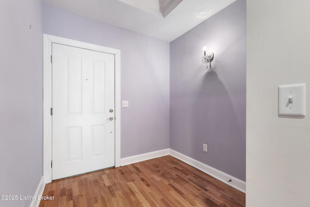 foyer entrance featuring baseboards and wood finished floors