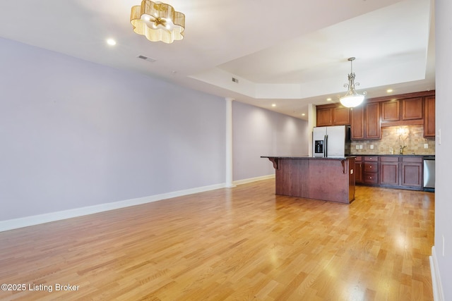 kitchen with visible vents, a breakfast bar area, appliances with stainless steel finishes, and a tray ceiling