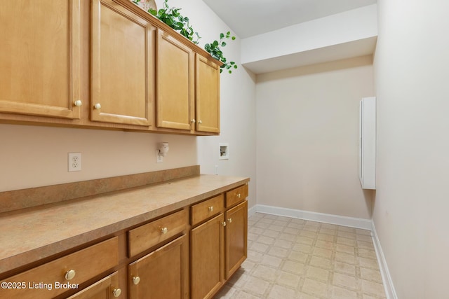 kitchen with light floors, brown cabinetry, light countertops, and baseboards