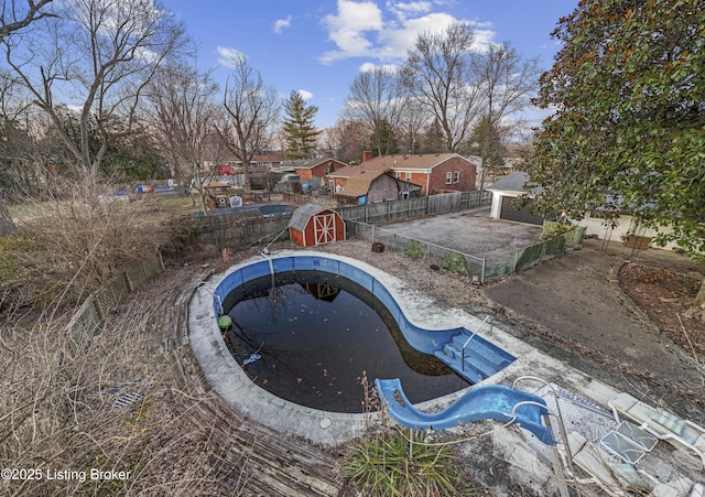 view of swimming pool featuring an outdoor structure and a fenced backyard