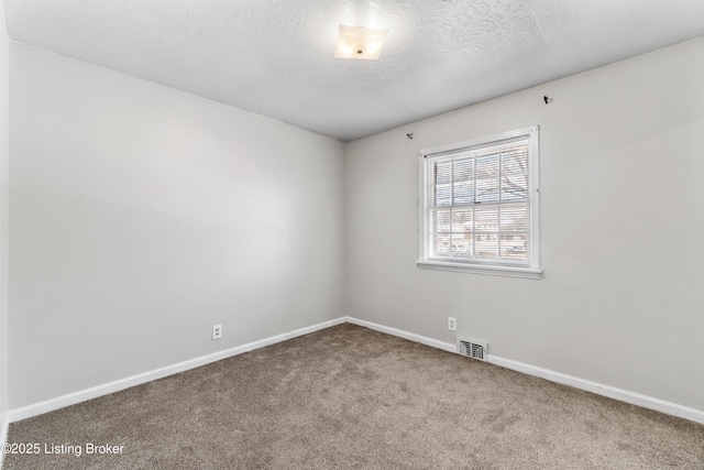 unfurnished room featuring a textured ceiling, carpet floors, visible vents, and baseboards