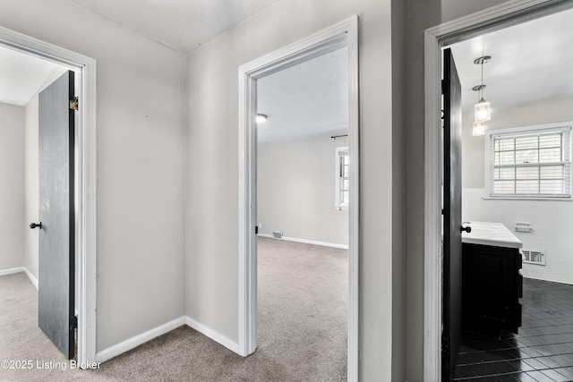 corridor featuring carpet, visible vents, and tile walls